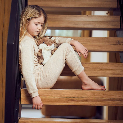 young girl sitting with brown hamster microwavable toy wheat filled with lavender scent